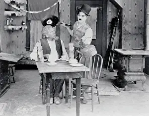 Prints of (Original Caption). Charlie Chaplin about to spill a fried egg on his colleague's head. Movie still from Sunnyside, 1919 Master of Mime, Icon of Cinema: Chaplin in Prints: Charlie Chaplin in Sunnyside