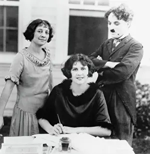 Prints of (Original Caption). Lita Grey Chaplin signing contract to be leading lady in next movie with Charlie Chaplin (right) as Mrs. Lillian Spicer (Lita's mother) looks on Master of Mime, Icon of Cinema: Chaplin in Prints: Charlie and Lita Grey Chaplin with Her Mother