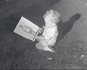 Infancy Prints: Charlie Paddock's Son Admiring Picture