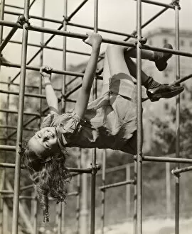 Retrofile Gallery: Child girl hanging upside down on jungle gym
