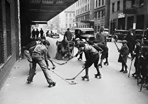 Prints of (Original Caption) 1/19/1932-New York, NY- The sidewalks of New York, famous in song and legend, offer these youngsters an ideal rink during an exciting roller-skating hockey match Frozen Moments: A Journey Through Hockey History: Children Playing Sidewalk Roller Hockey