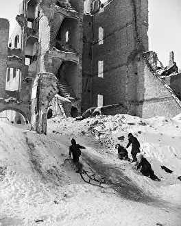 Children Playing in Snow Near Ruins