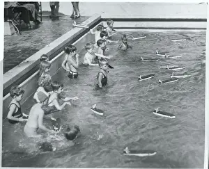 Children Racing Boats in Pool