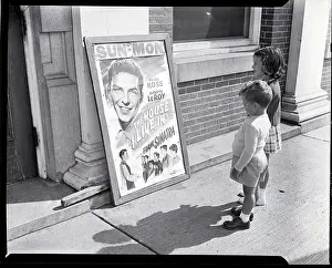Two Children Stand in Front of Theater