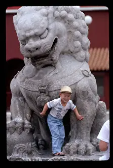Chinese Boy Poses with Statue of Lion