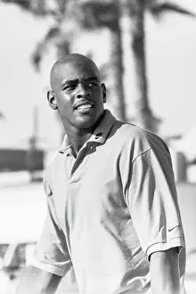 Prints of Chris Webber of the Golden State Warriors walks on the beach wearing a polo shirt with the Nike swoosh on the collar and sleeve during the filming of a Nike commercial in 1994 in Venice, California Timeless Moments: A Visual Journey Through History’s Defining Images: Chris Webber Nike Commercial