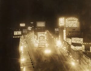 circa 1920: High-angle view of illuminated marquees in Times Square at night