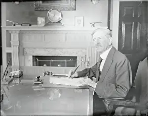 Claude A. Swanson Writing at Desk