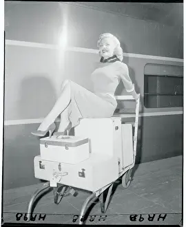 Cleo Moore Posing Atop Her Luggage