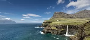 Faroe Islands Collection: Cliffs with a waterfall near a village, Mykines Island at the rear, Gasadalur, Vagar