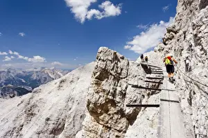 Alpen Prints: Climber climbing along the Via Ferrata Ivano Dibona climbing route on Monte Cristallo to the summit of Cristallino