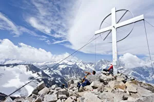 Climbers by the summit cross, Mt Vertainspitze, Ortler range, Mt Koenig at back South Tyrol, Italy, Europe