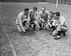 College Football Coaches Conversing in Huddle