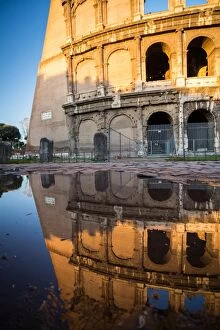 Images Dated 7th March 2015: The Colosseum reflected in a puddle at sunrise in Rome, Italy