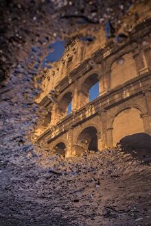 Images Dated 7th March 2015: The Colosseum reflected in a puddle at sunrise in Rome, Italy