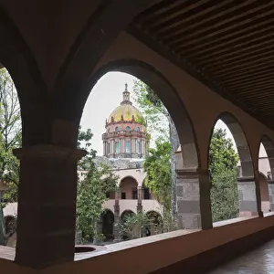 Colourful Church of the Nuns with dome viewed through arches