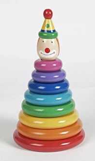 Colourful plastic rings stacked on pole with smiling clown head at the top, close up