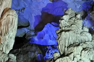 Colourfully, illuminated rock formation in Hang Sung Sot cave, Surprise Cave, Cave of Awe, a UNESCO World Heritage Site
