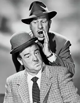 Comedian Bud Abbott Whispering to Lou Costello