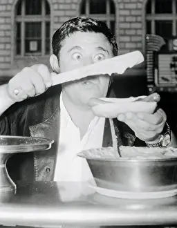 Comedian Buddy Hackett Preparing a Hot Dog