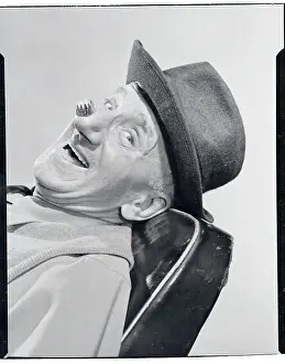 Comedian Jimmy Durante Wearing a Hat and Crown on His Nose