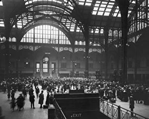 Commuters crowd the terminal of Pennsylvania Station, preparing to leave town for