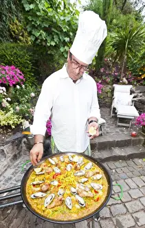 Spanish Prints: Cook preparing a paella, a Spanish rice dish, adding lemon, series, no. 5