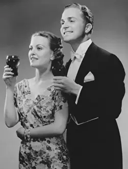 Couple dressed up holding drinks