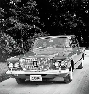 Couple Driving 1960 Plymouth Valiant