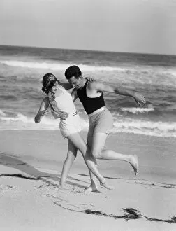 Swimming Gallery: Couple embracing on sandy beach