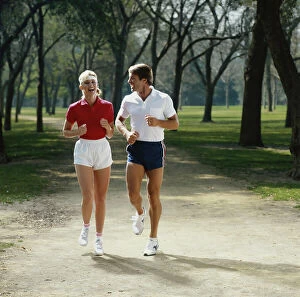 Images Dated 3rd July 2011: Couple jogging in park, smiling