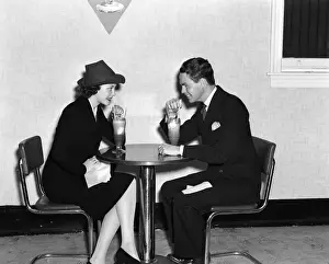 Cafe Prints: Couple In Luncheonette Both Are Sitting At A Table Wearing Dark Suits & Eating An