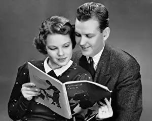 Couple reading magazine together