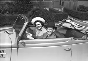 Couple riding in old fashion convertible car, (B&W), , portrait