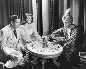 Eerie Prints: Couple Seated at Table with Swami
