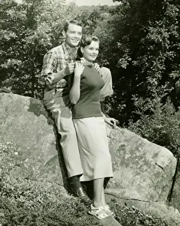 Mid Adult Couple Prints: Couple sitting on boulder in park, (B&W)