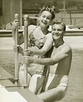 Railing Collection: Couple standing at railings in pool, (B&W), portrait