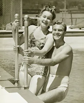 Railing Collection: Couple standing at railings in pool, (B&W), portrait