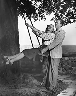 Couple w / woman on swing