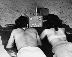 Portable Prints: Couple Watches Portable Tv On Beach