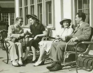 Two couples relaxing outside, (B&W)