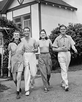 1960s Fashion Collection: Two couples walking on lawn in front of house (B&W)