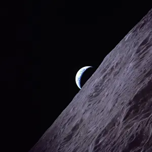 Crescent Earth rises above the lunar horizon in this picture from the Apollo 17