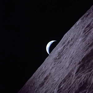 Crescent Earth rises above the lunar horizon in this picture from the Apollo 17