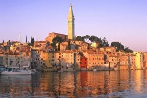Images Dated 10th January 2007: Croatia, Rovinj, church tower & harbour at sunrise seen from water