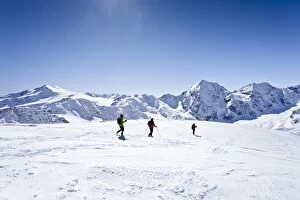 Cross-country skiers during the descent from Hintere Schoentaufspitze Mountain, overlooking Zufallspitze, Cevedale