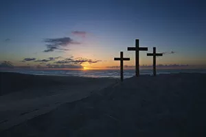Images Dated 16th December 2014: Three crosses on a sand dune next to the ocean with a cloudy sunrise