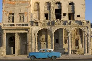 Havana Gallery: Cuba, Havana, blue car passing building on street