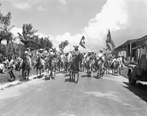Cuban Cavalry Rides Down Street with Flags