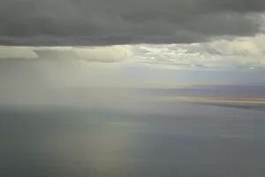 Cumulus clouds and rain showers over sea, aerial view